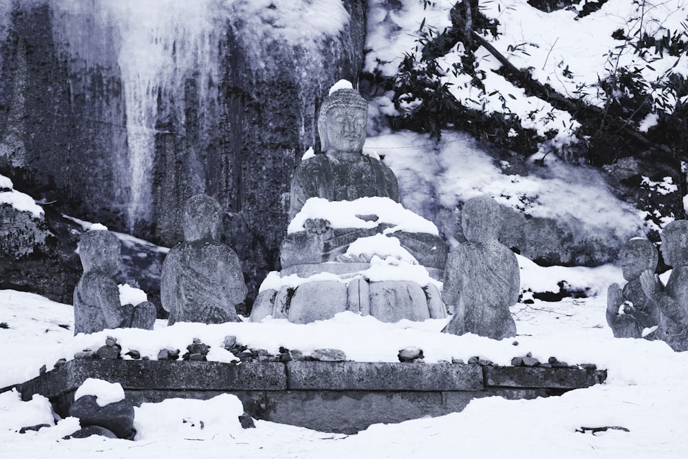 a group of stone statues covered in snow