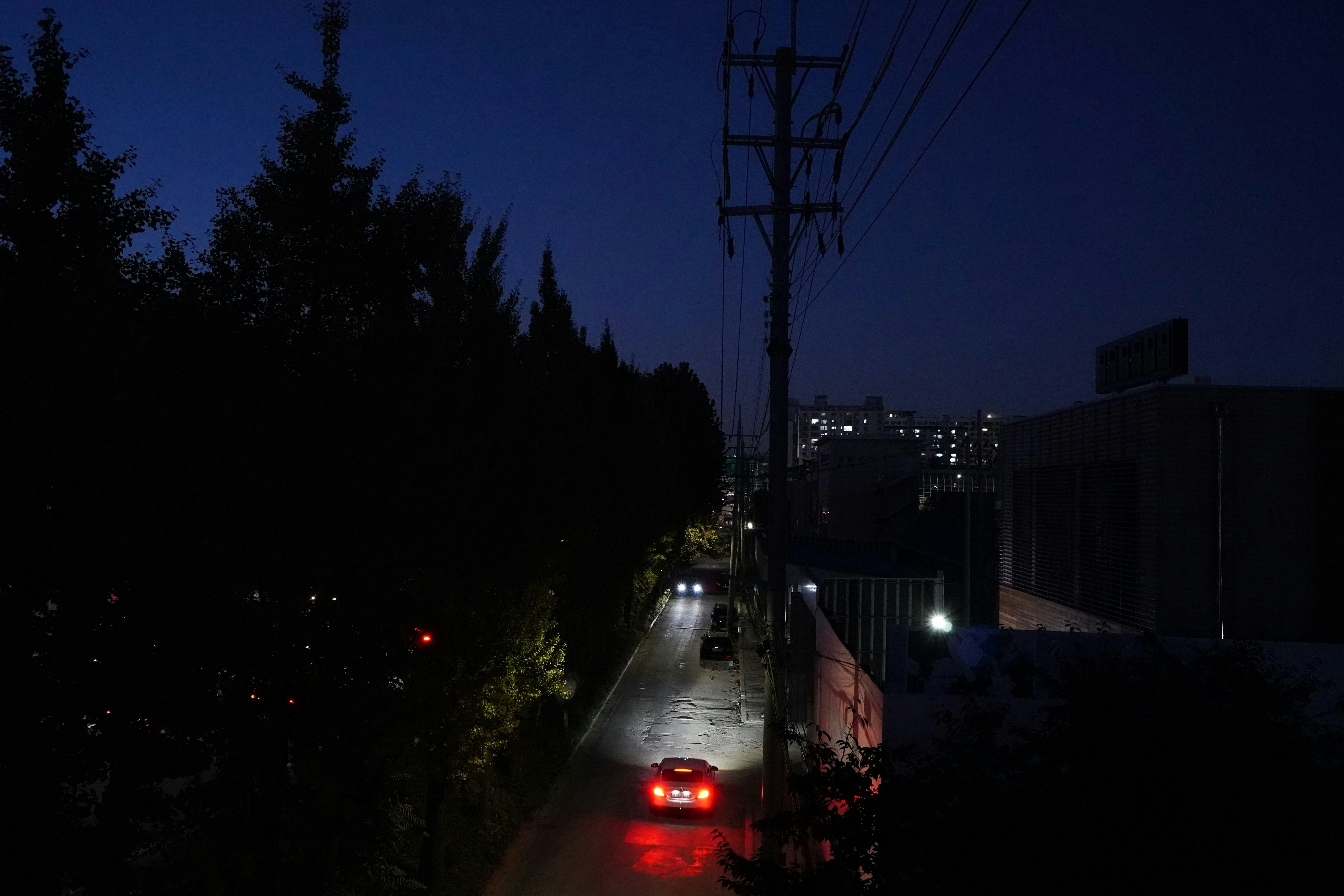 a car driving down a street at night
