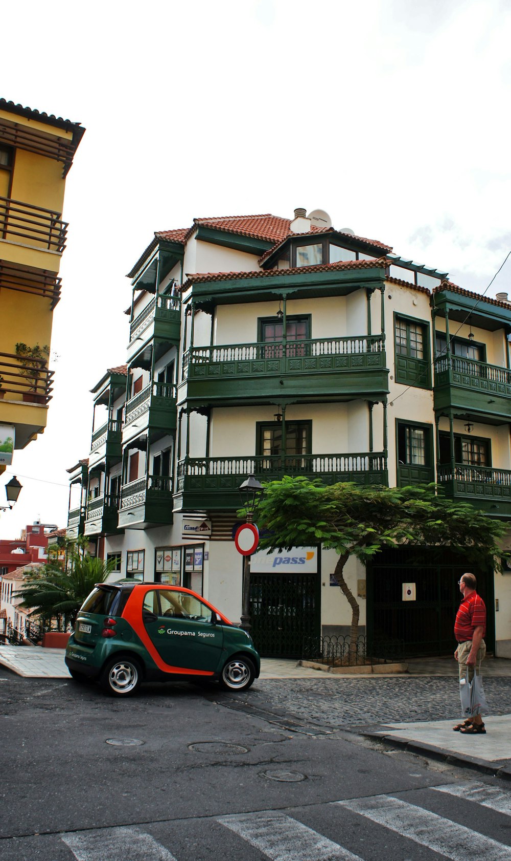 건물 앞에 주차된 녹색과 빨간색 차량