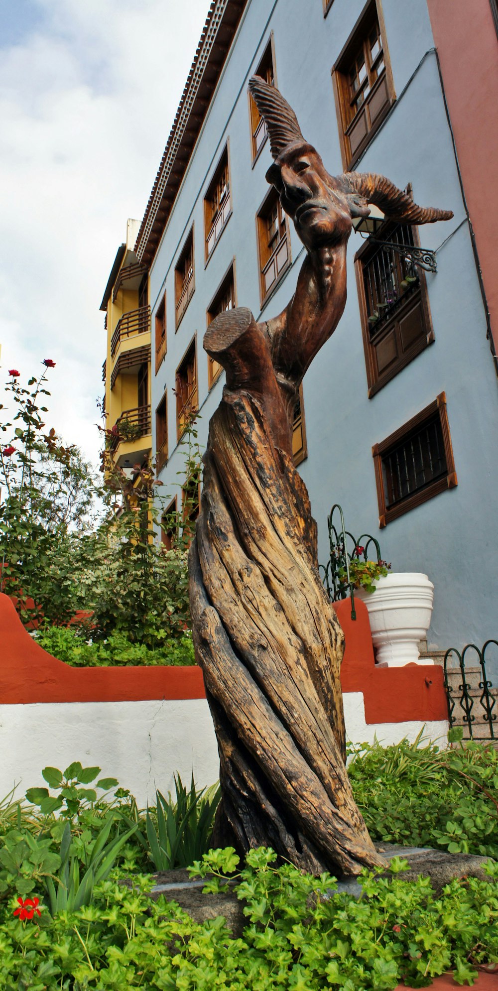una statua di un uccello appollaiato su un tronco d'albero