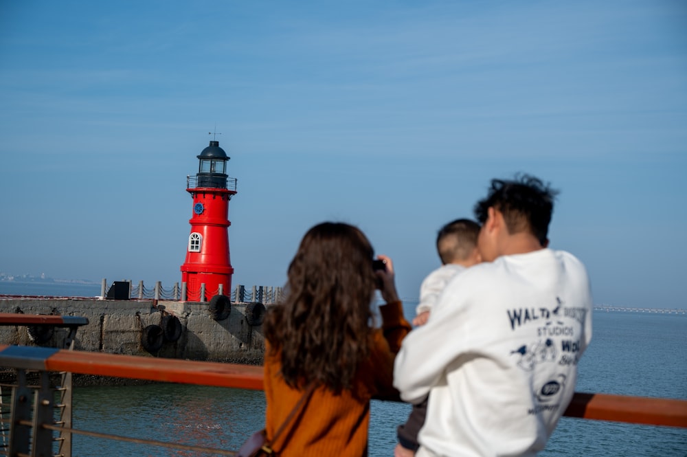 a man and a woman looking at a red light house