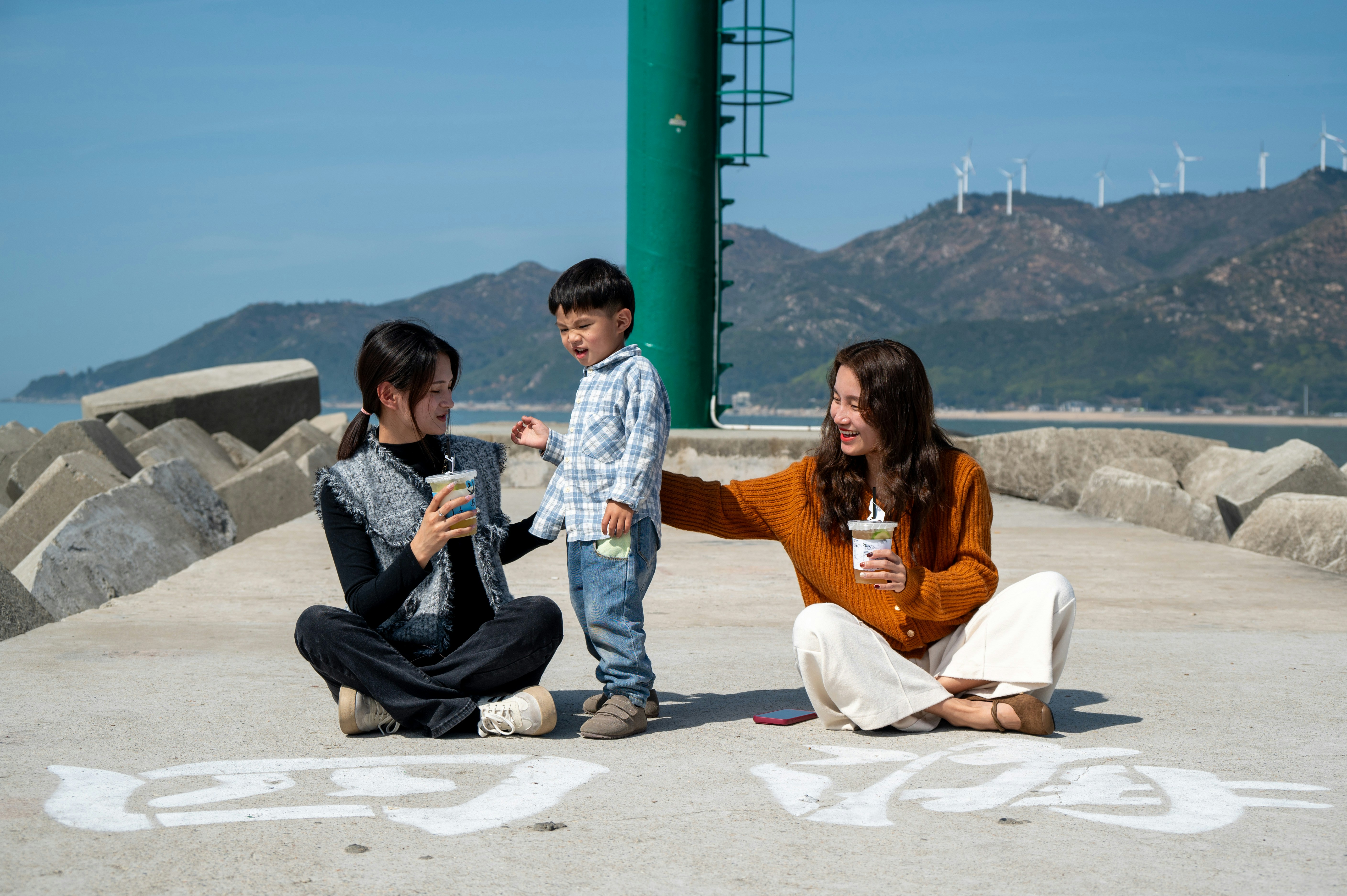 a woman sitting on the ground with two children