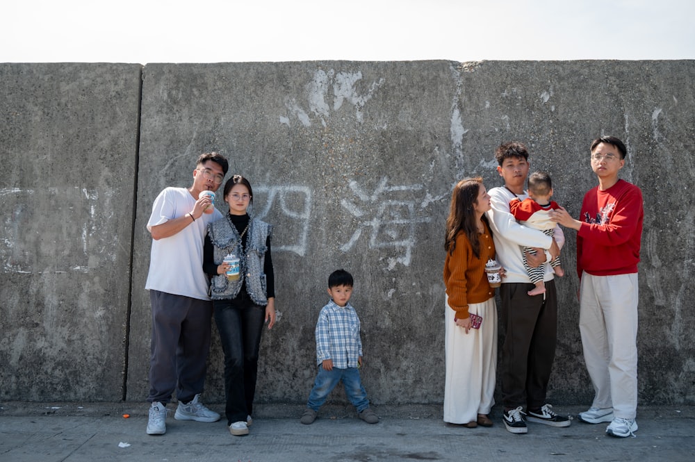 a group of people standing in front of a wall