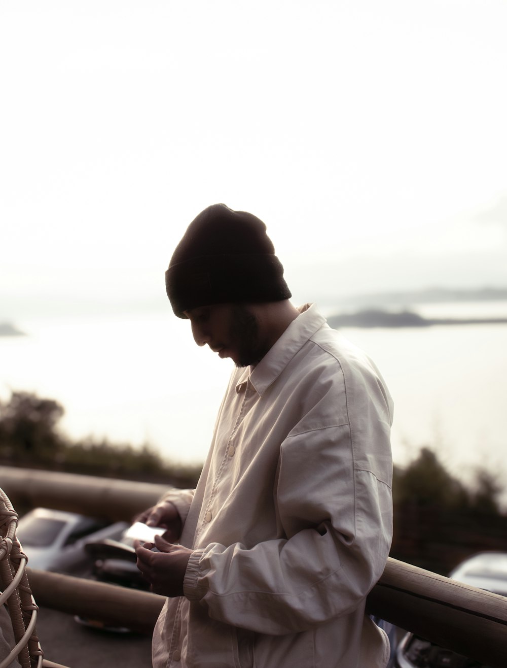 a man standing on a balcony looking at his cell phone