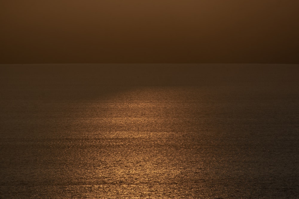 a large body of water with a plane flying over it