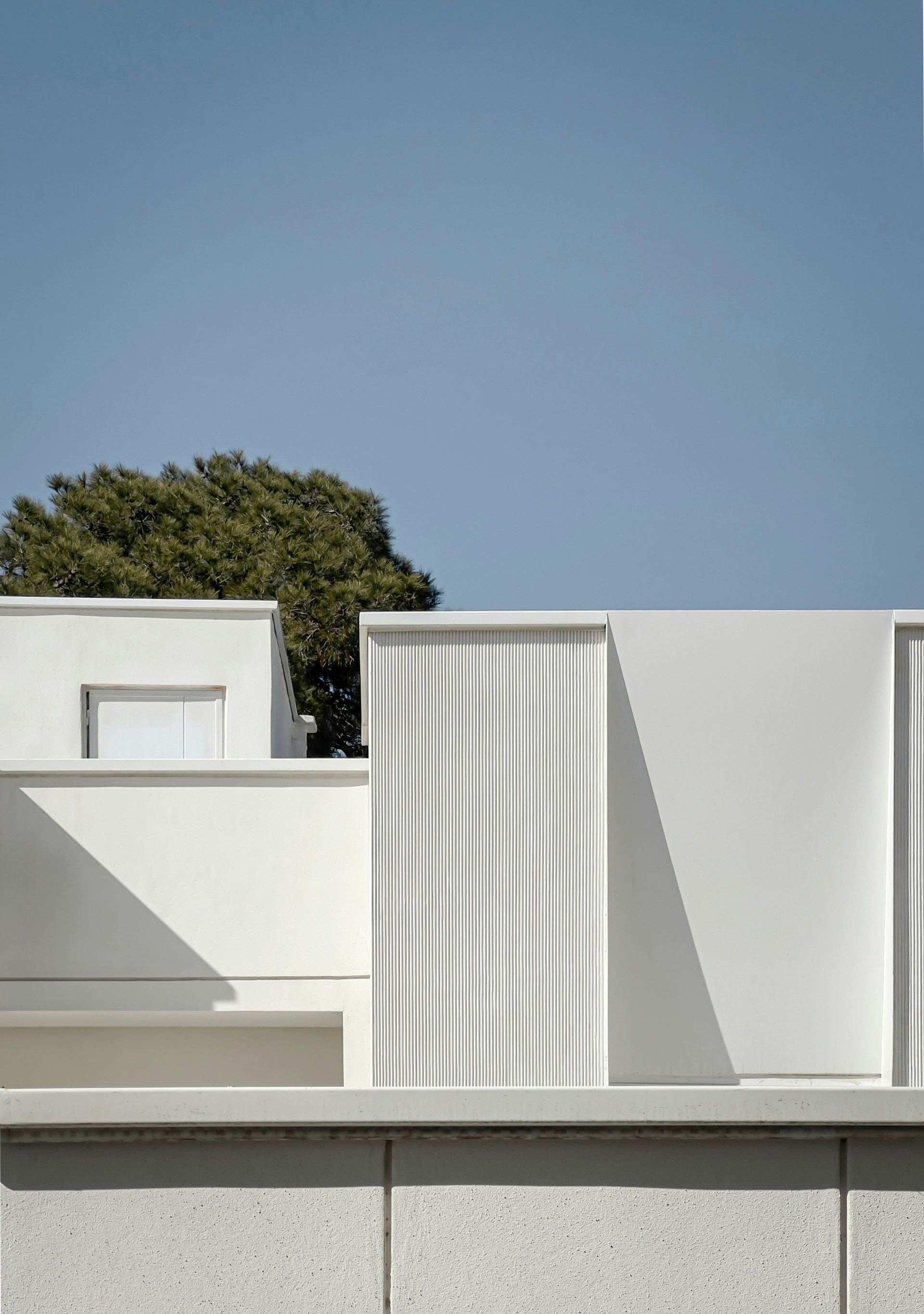 a white building with a tree in the background