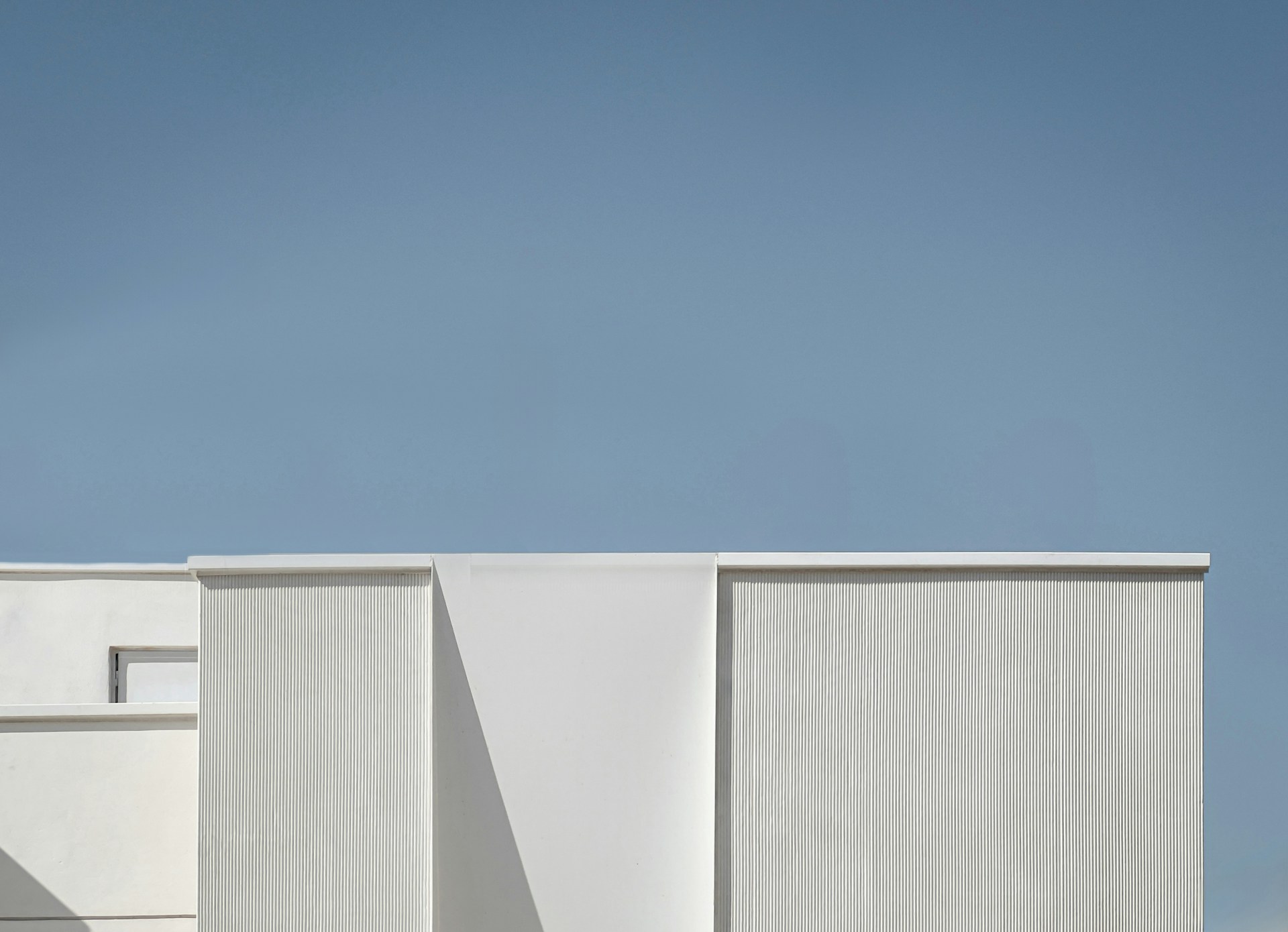 a tall white building with a clock on it's side