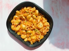 a black bowl filled with macaroni and cheese