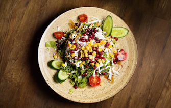 a plate of salad on a wooden table