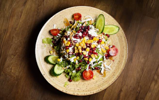 a plate of salad on a wooden table