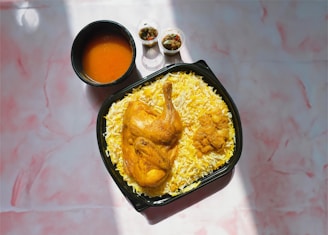 a plate of chicken and rice with sauces