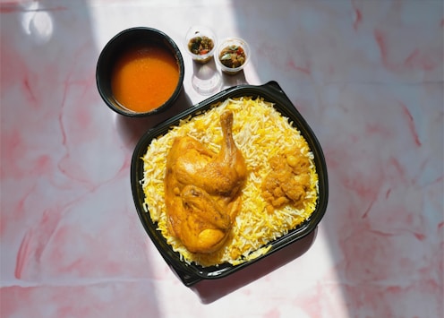 a plate of chicken and rice with sauces