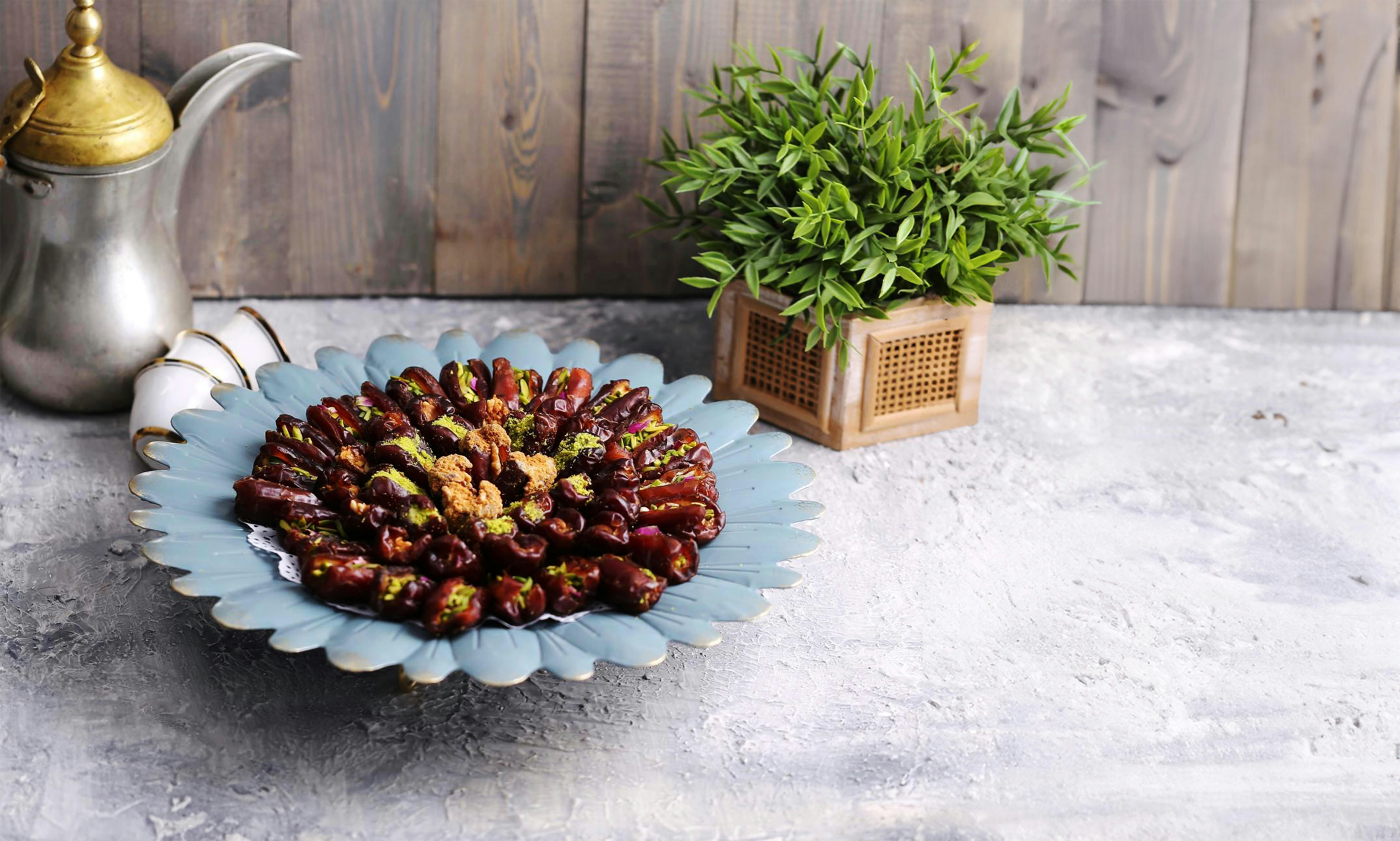 a plate of nuts next to a potted plant