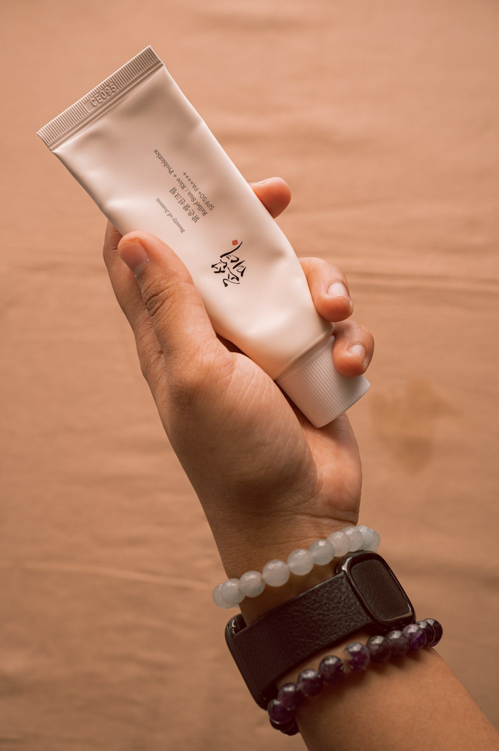 a person holding a tube of cream in their hand