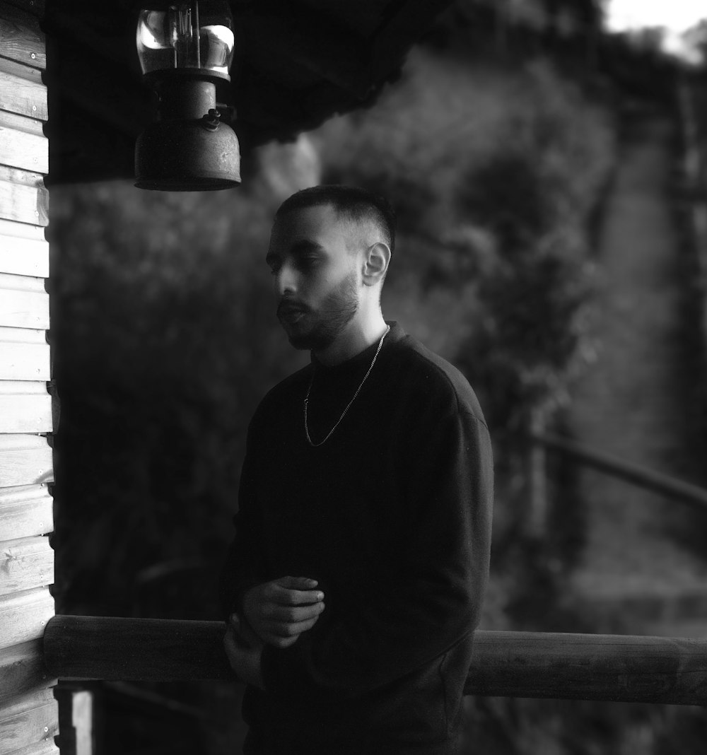 a man standing next to a wooden building