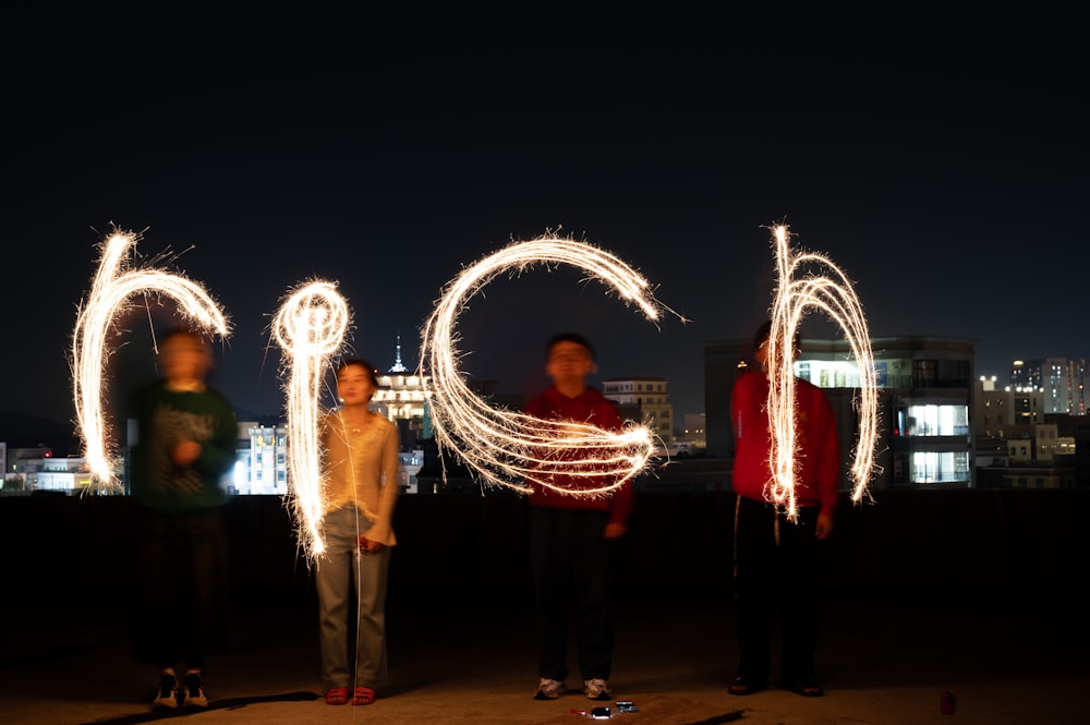 a group of people standing next to each other holding sparklers