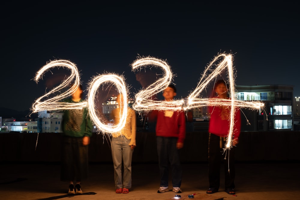 a group of people standing next to each other holding sparklers