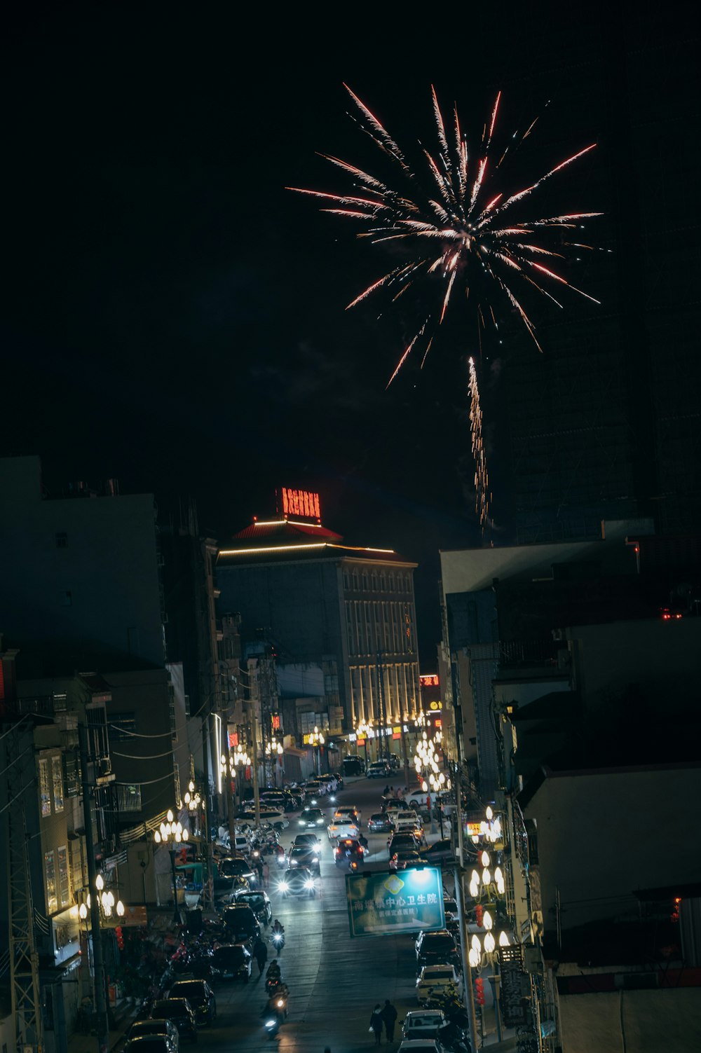 a city street filled with lots of traffic and fireworks