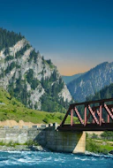 a bridge over a river with mountains in the background