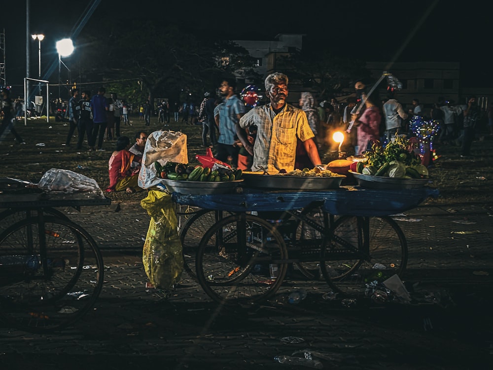 a group of people standing around a blue cart