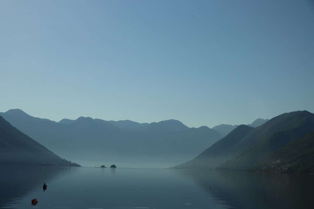 a body of water with mountains in the background