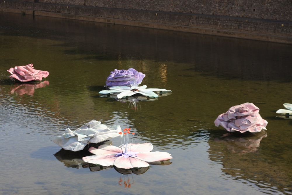 a group of paper flowers floating on top of a body of water