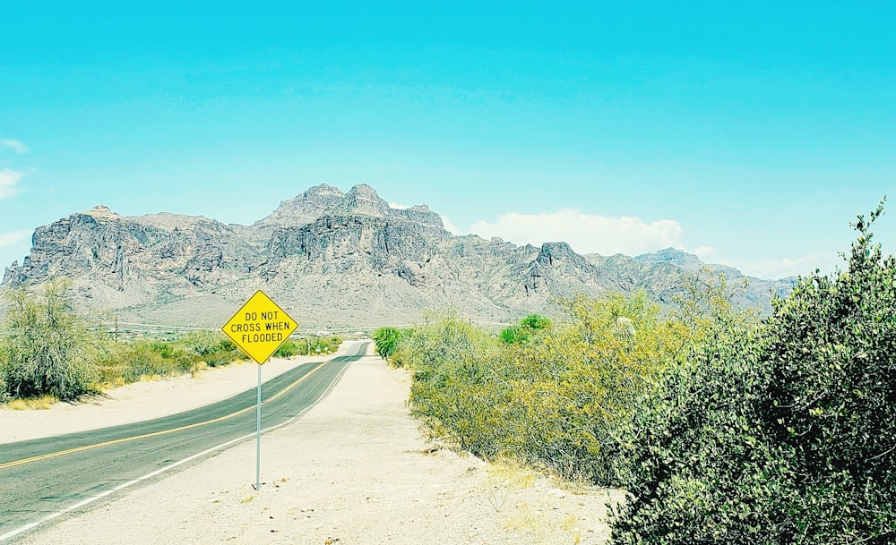 a yellow street sign sitting on the side of a road