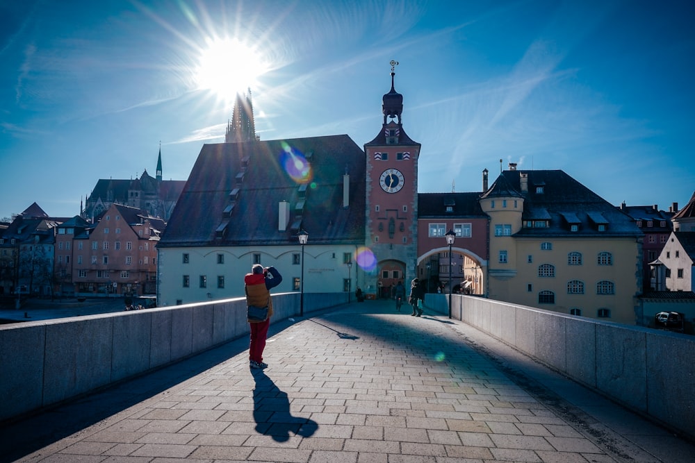 a person standing on a bridge with buildings in the background