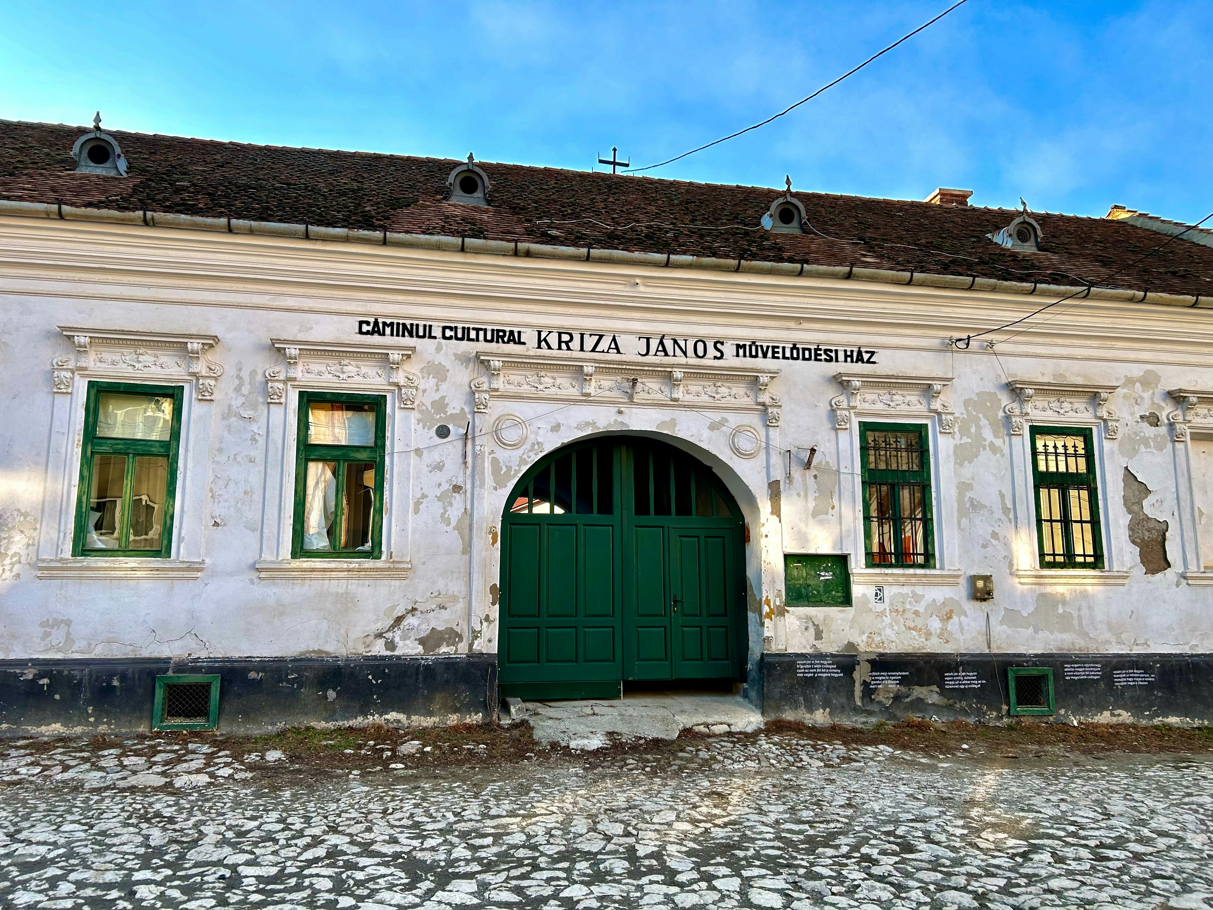 a white building with a green door and windows