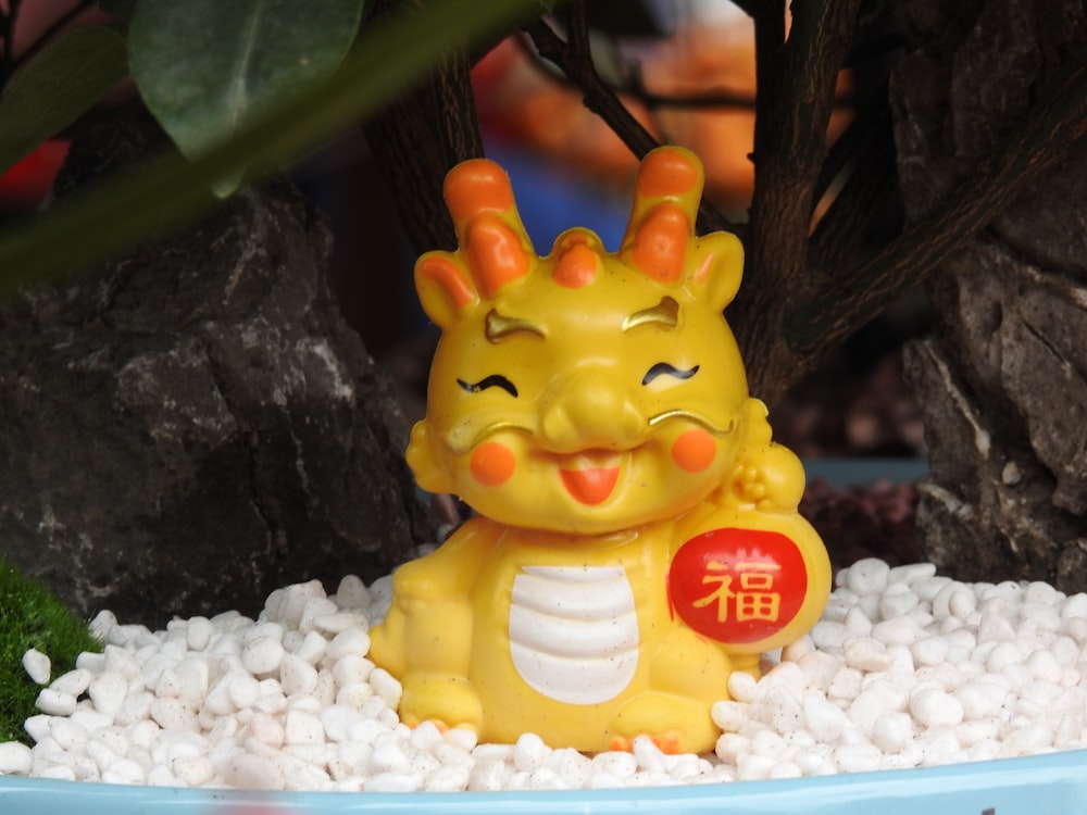 a yellow toy sitting on top of a pile of white rocks