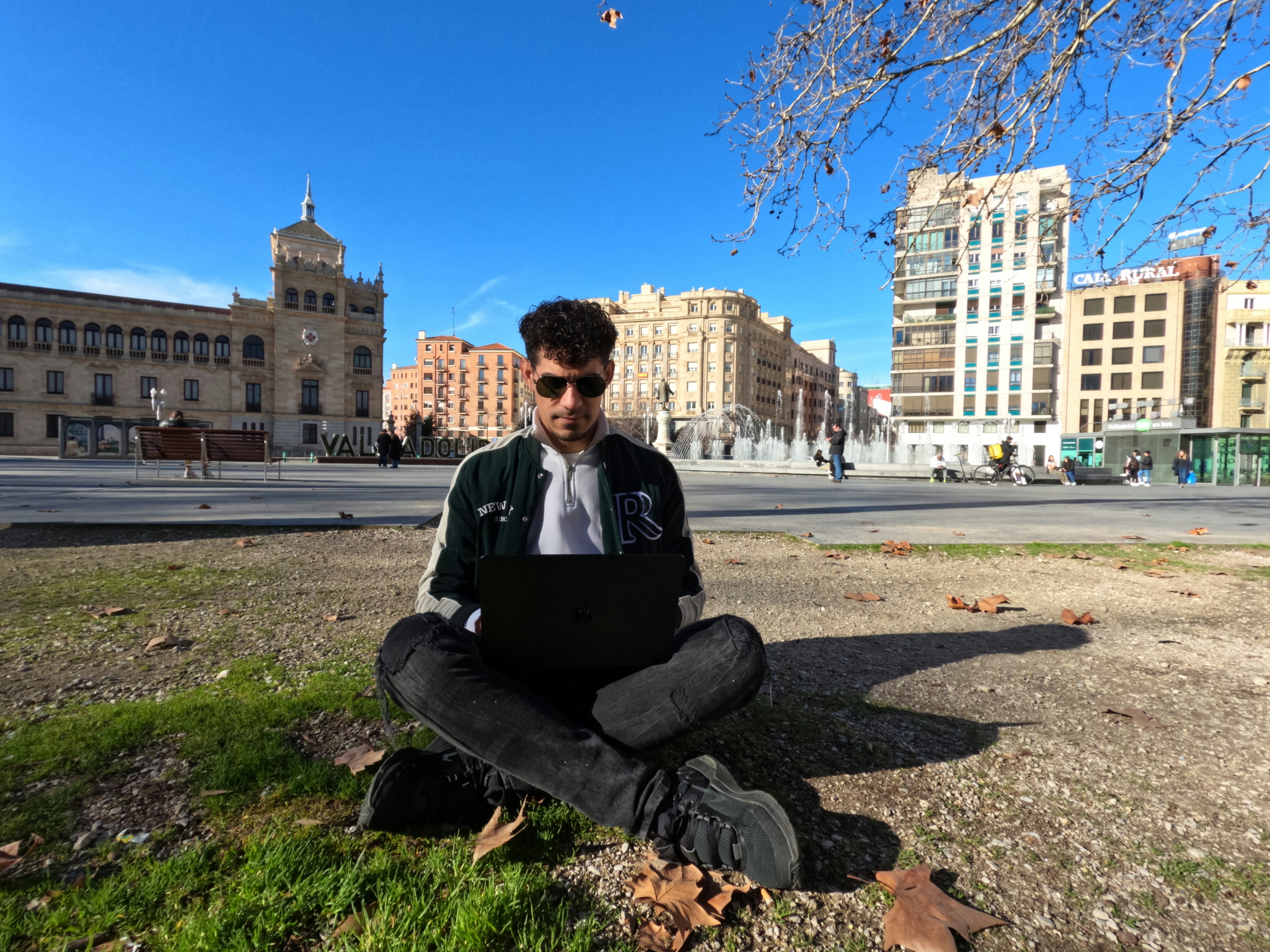 a man sitting on the ground with a laptop, Trabajo Remoto
