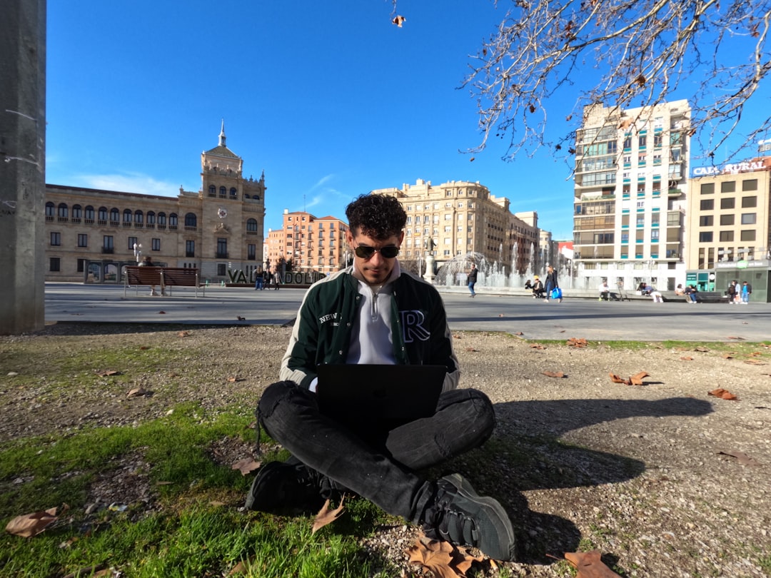 a man sitting on the ground using a laptop, Trabajo Remoto