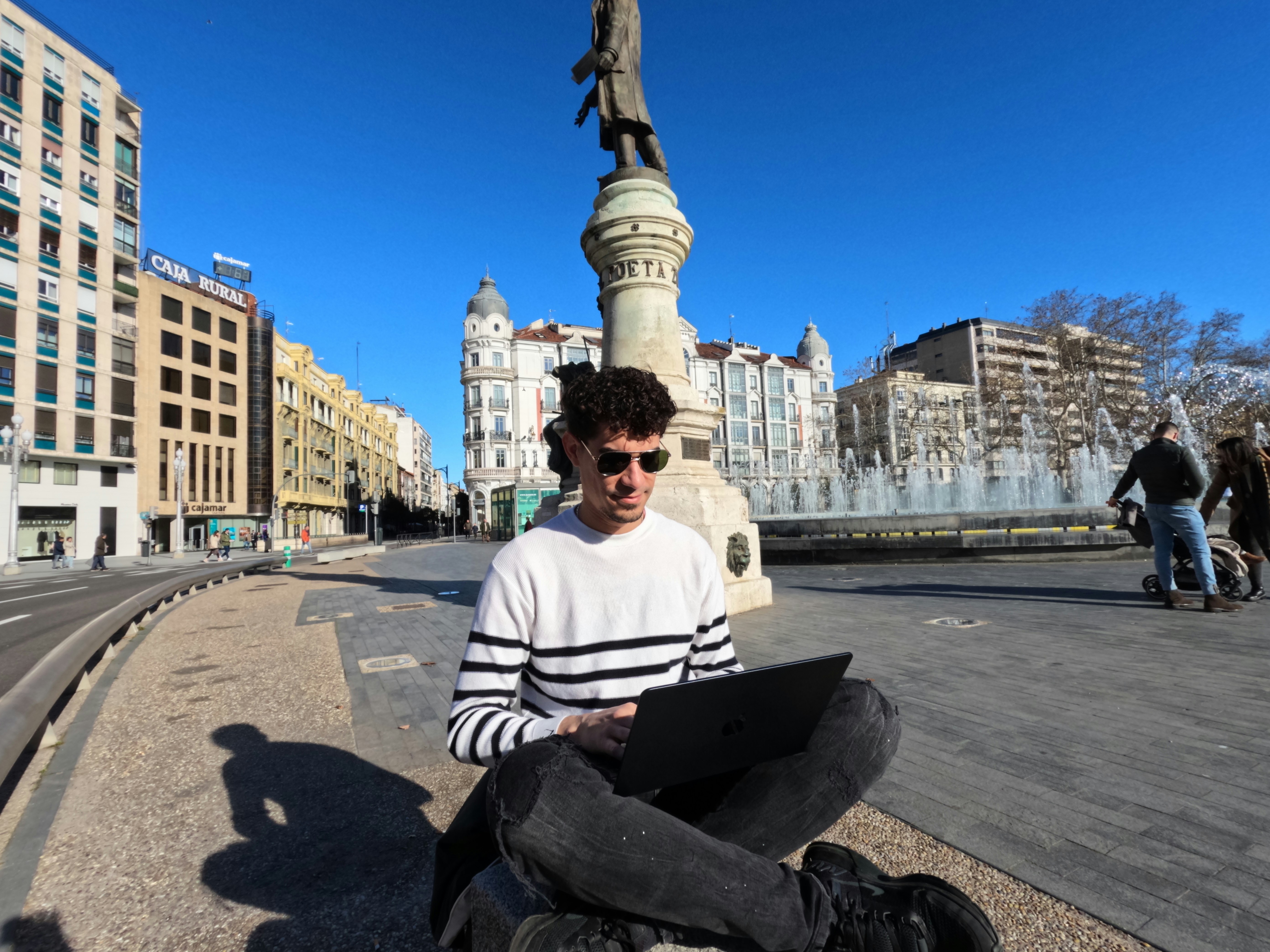 a man sitting on the ground using a laptop