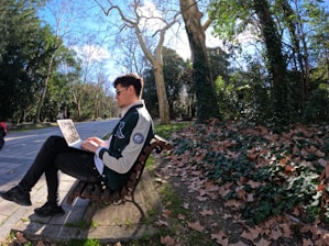 a man sitting on a bench reading a newspaper