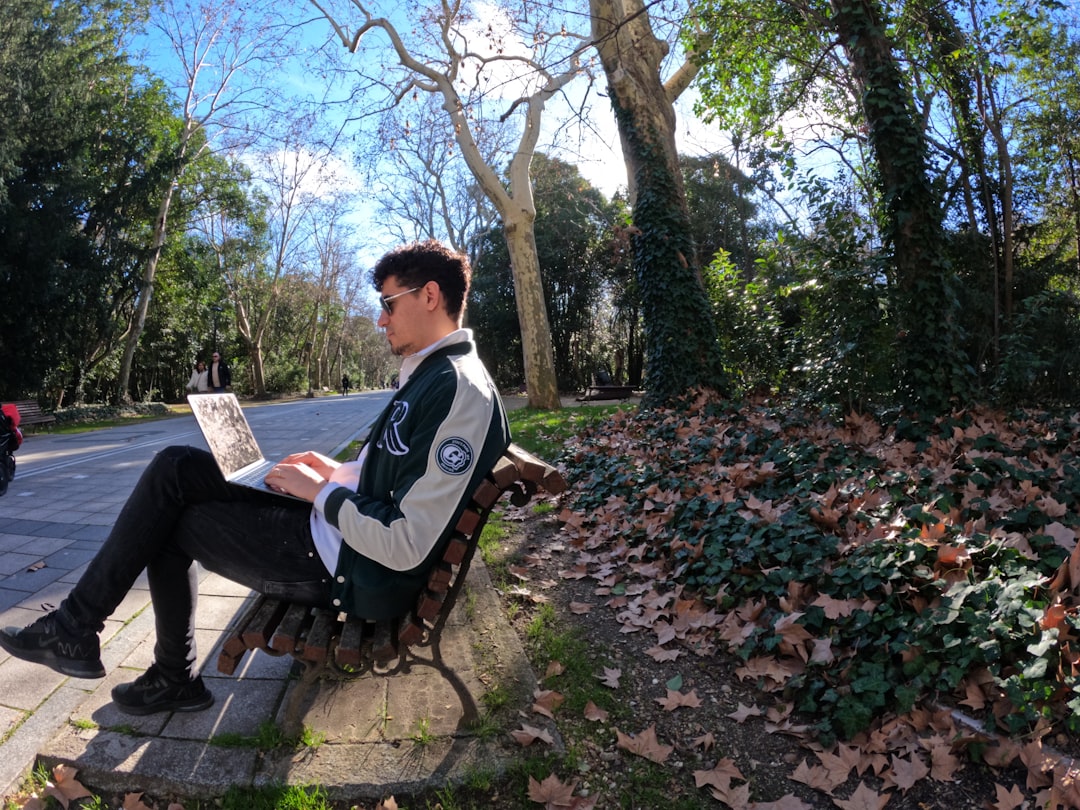 a man sitting on a bench reading a newspaper, Trabajo Remoto