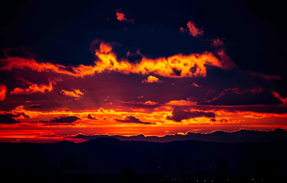 a red and orange sunset with clouds in the sky