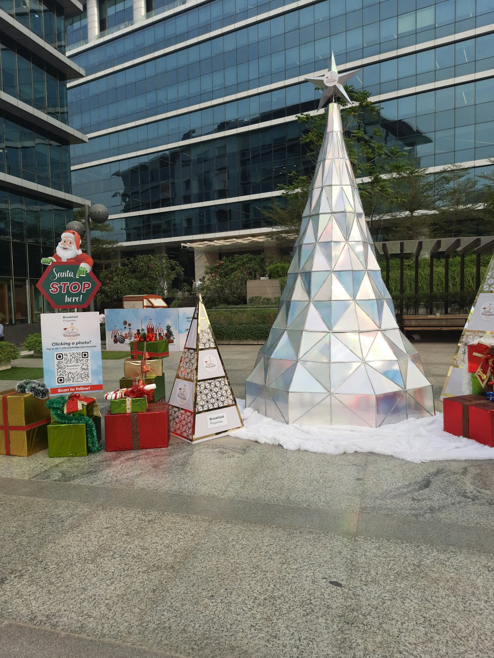 a group of christmas trees sitting in front of a building