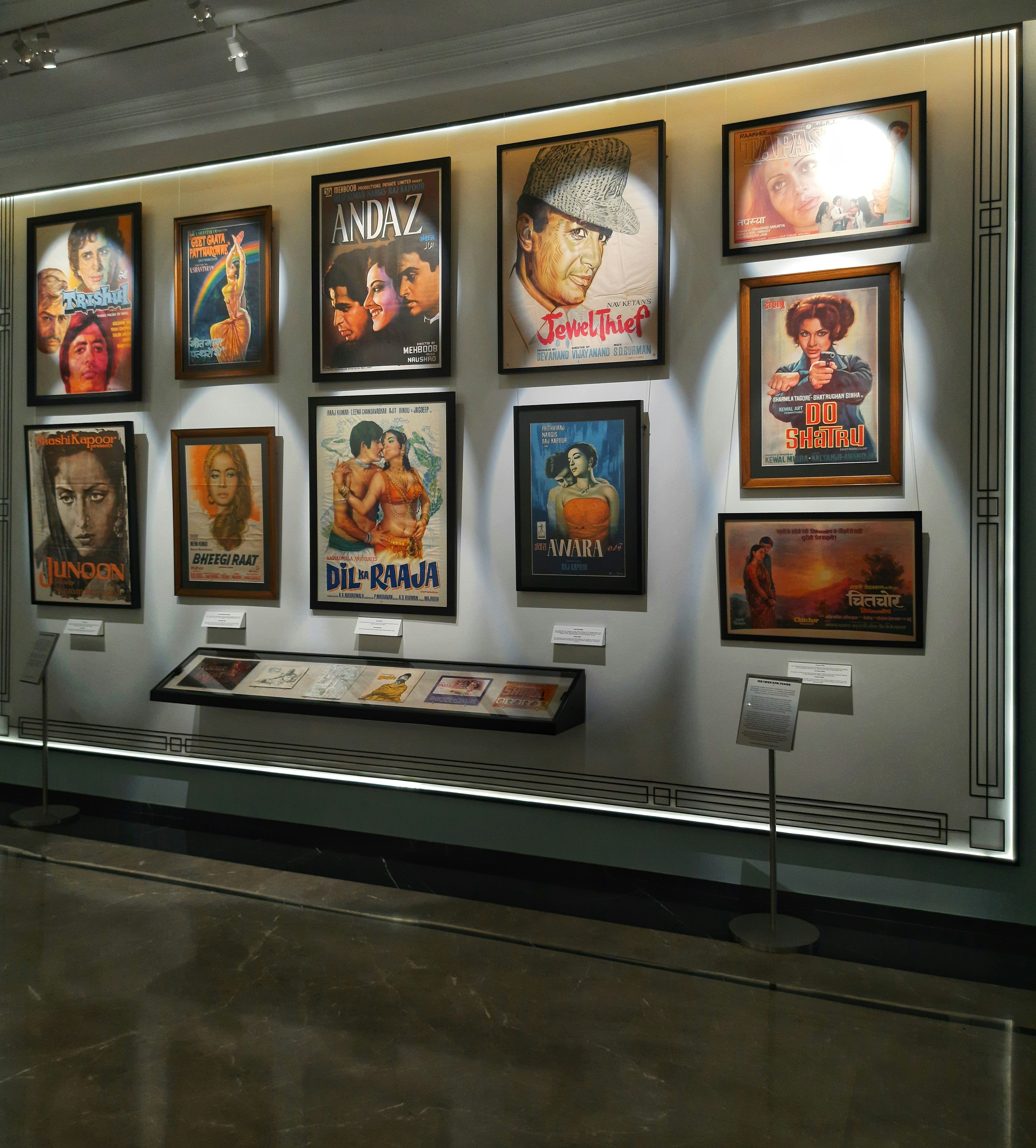 Vintage film posters on dark wall, moody warm lighting