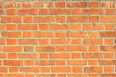 a red brick wall with a clock on it