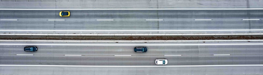 three cars driving down a highway next to each other