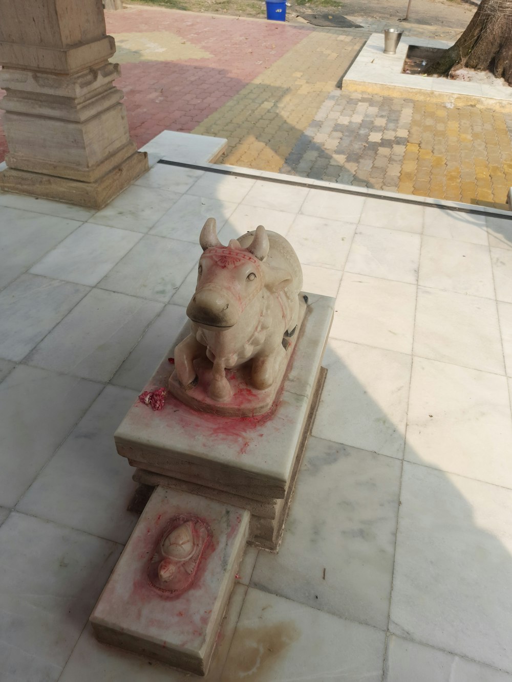 a statue of a rhino on a stone bench