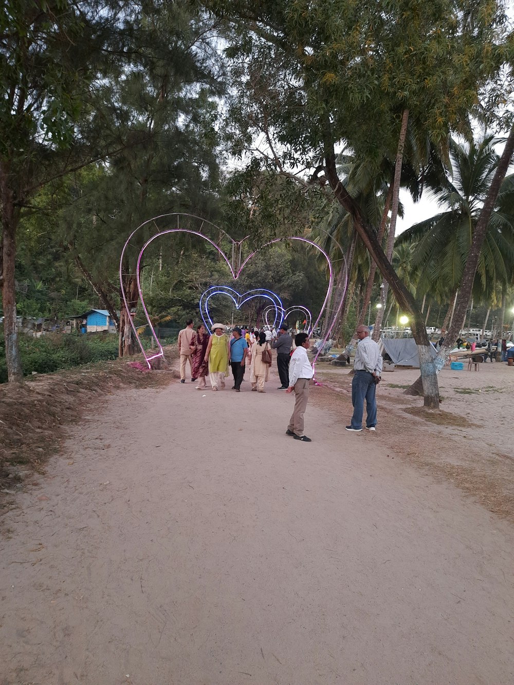 a group of people walking down a dirt road