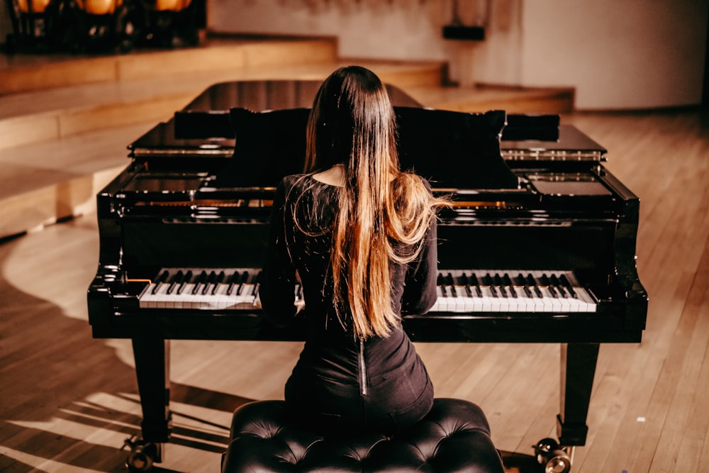 a woman sitting at a piano in a room