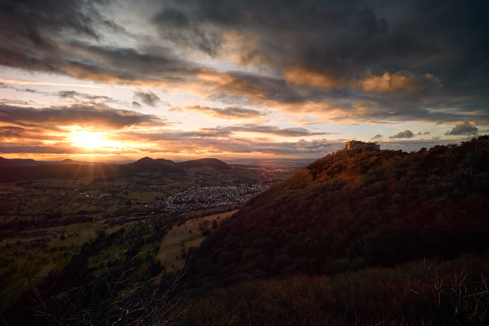 the sun is setting over the mountains and valleys