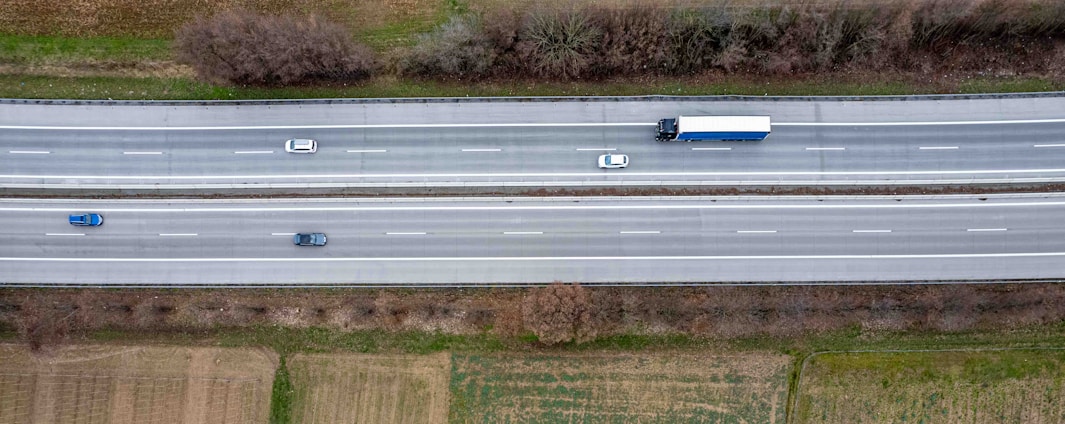an aerial view of two trucks driving down a highway
