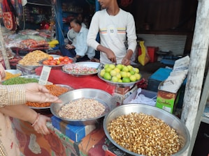 a group of people standing around a table filled with food