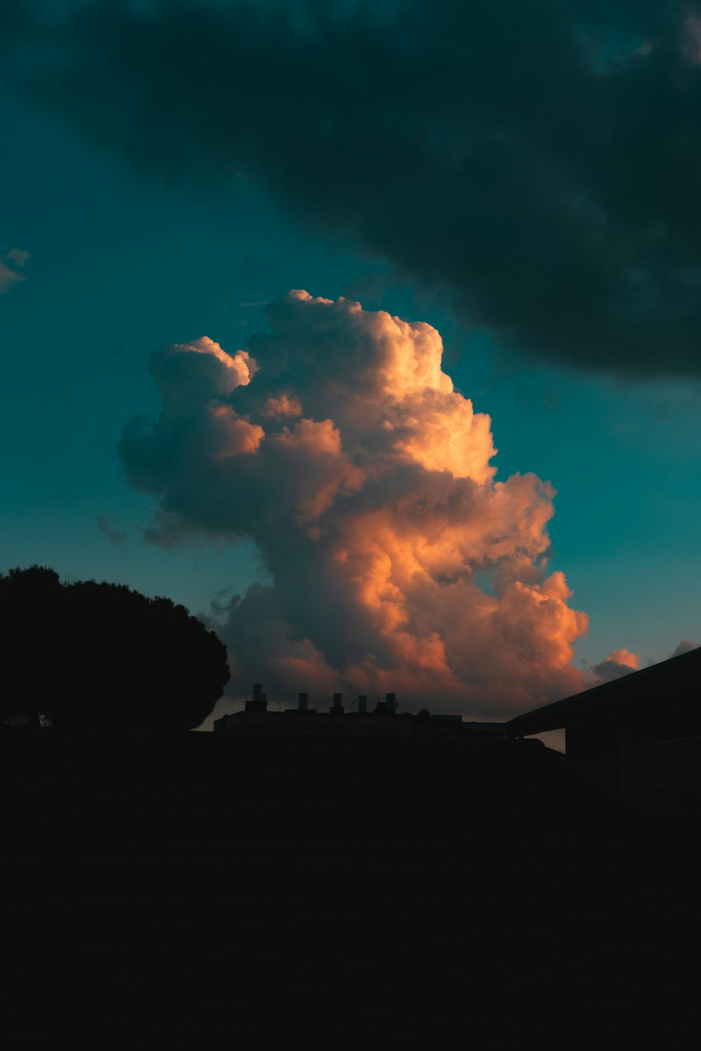 a large cloud is in the sky above a house