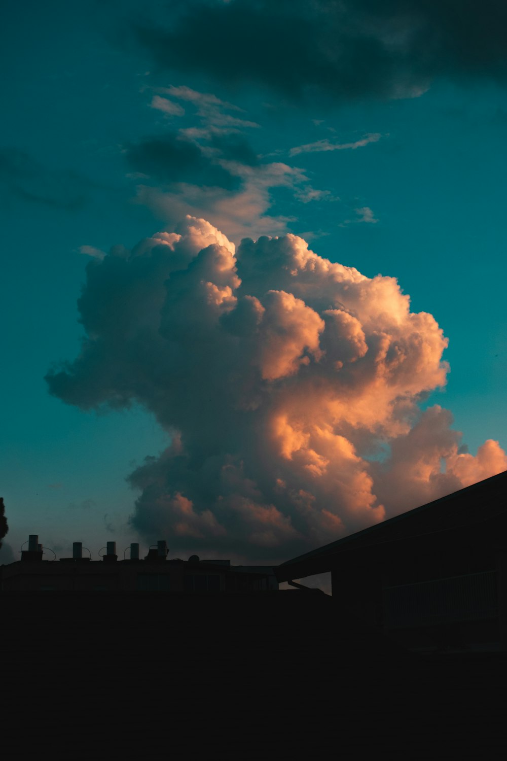 a large cloud is in the sky above a building