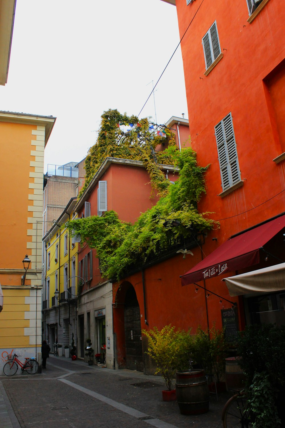 a narrow city street with buildings and a bicycle parked on the side of the street