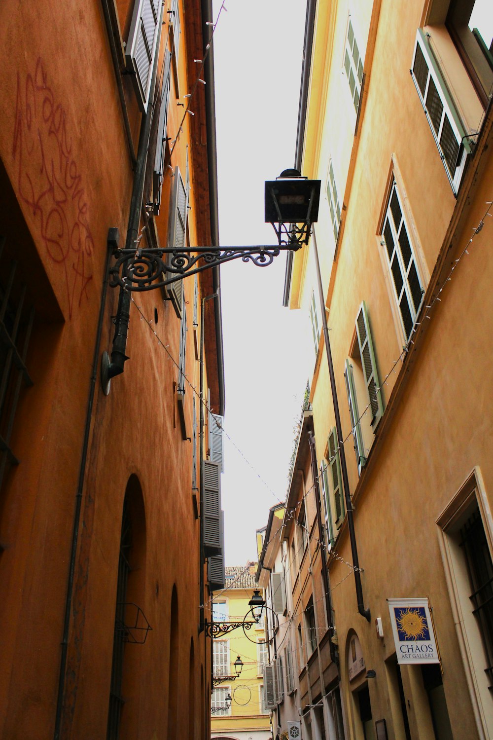 a narrow alleyway with graffiti on the side of buildings